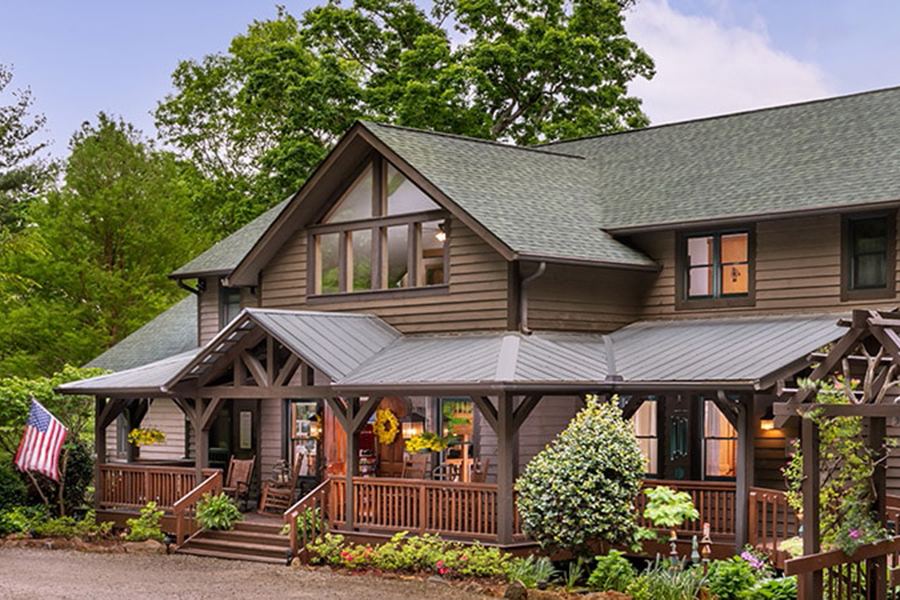 The front of Bent Creek Lodge, a timber lodge with porches in the Bent Creek woods
