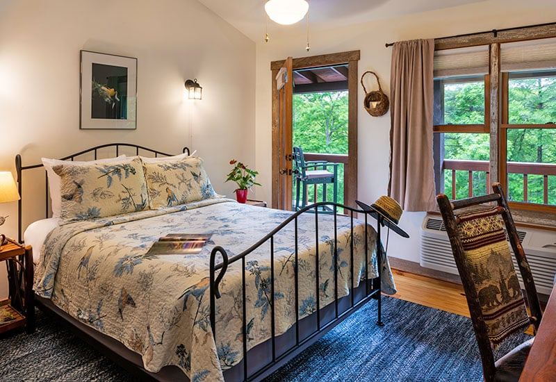 The Bird Room at Bent Creek Lodge with a queen iron bed and bird themed decor