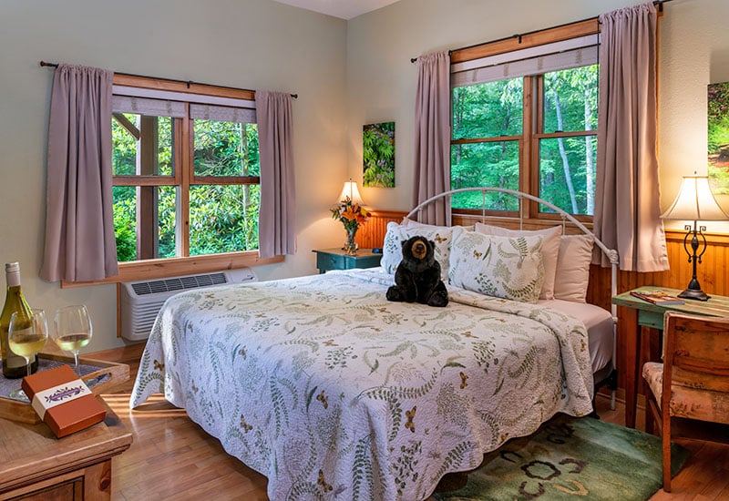 The Fern Room at Bent Creek Lodge with a king bed in soft green tones and a jetted tub