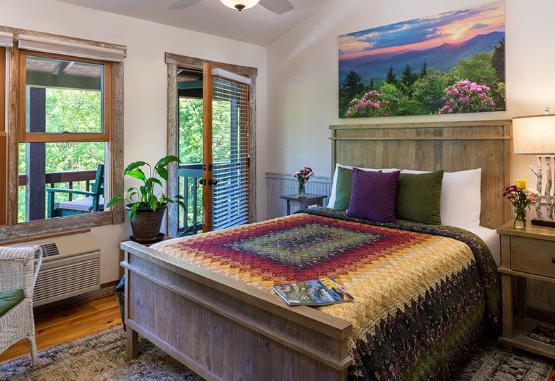 The Rhododendron Room at Bent Creek Lodge with a weathered gray queen bed and rhododendron artwork