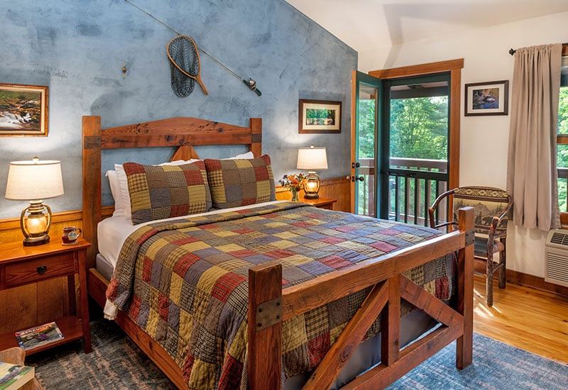 The Water Room at Bent Creek Lodge with a heart pine trestle bed and blue accent wall