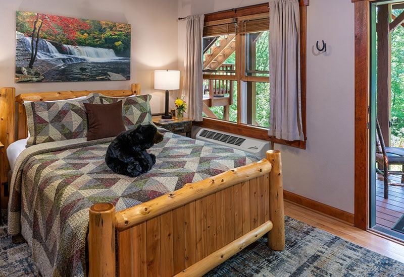 The Waterfall Room at Bent Creek Lodge with a rustic pine log queen bed and waterfall photographs