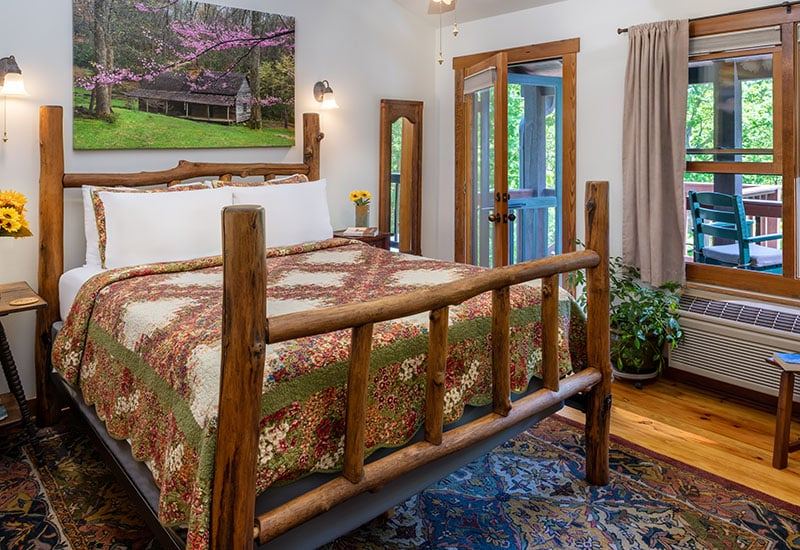 The Wildflower Room at Bent Creek Lodge with a locust log queen bed and balcony doors